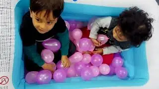 Kids enjoying in pool full of balloons.