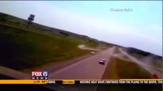 SUV goes airborne when it hits a bump in the road