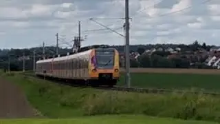 Z&uuml;ge in Ried mit Orangener Karriere S Bahn mit Lichtgru&szlig; 