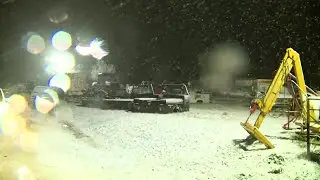 Snowfall accumulating on grassy areas in northern Oklahoma