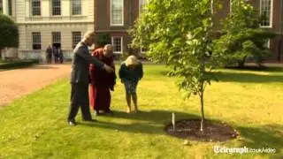 Prince Charles walks holding hands with Dalai Lama