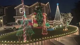 Custom Christmas lights holiday display on a house bushes blowups trees