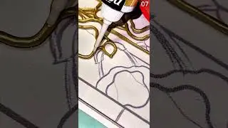 Applying gold paint with white tool on outlined design