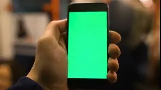4k close up of hand holding a smartphone with green screen display at