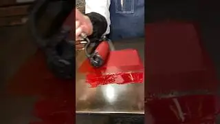 Rolling out rhodamine red ink in preparation for letterpress printing
