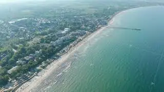 Baltic sea aerial drone view, tourist beach summertime destination in Scharbeutz, Germany, tilt down