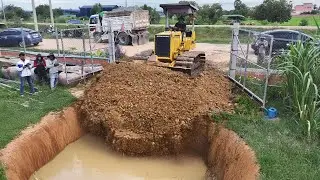 The project began filling flood protection land using a Dozer D31P pushing soil with a 5-ton truck.