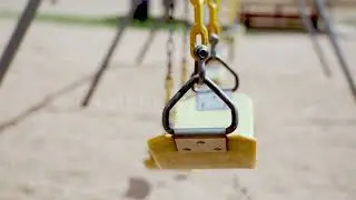 Stock Video - Empty swings blowing in the wind at a park in Texas