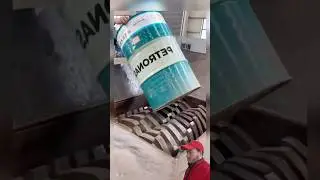 Powerful industrial shredder crushing a metal drum into piece