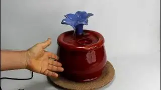 A ceramic cat drinking fountain with flower spout, handmade in the USA