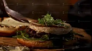 Male chef preparing burger at the restaurant kitchen. Stock footage. Close up of male hands adding
