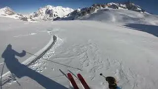 Skiing long open turns in wind blown snow