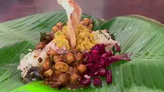 banana leaves and cooked red rice chickpea curry beetroot sample lentil curry papadum chip 