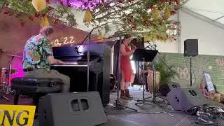 Tom McDermott playing at Jazz Fest 2025 with Aurora Nealand on sax and Michael Skinkus on congas