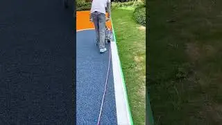 Precision Line Striping Applying a Bright White Border to a Newly Paved Blue Running Track