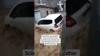 A man watches a car getting swept away by rushing floodwaters in China's Guangdong province.