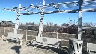 CSX’s mixed freight train and AMTK’s Northeast Regional passing Potomac Yard Metro station.