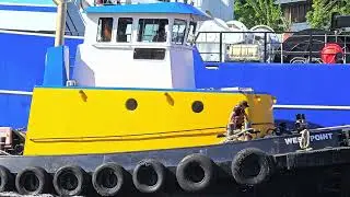 A tug with the fishing vessel Dominator on the Fremont cut, Seattle.