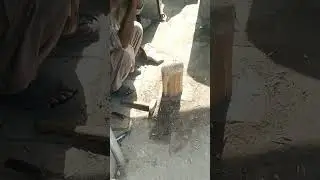 An eye catching scene of old man cutting wood into smaller pieces to burn it in stove by wooden axe