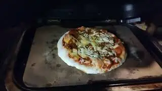 Pizza on a pizza stone on the Ninja Woodfire Pro