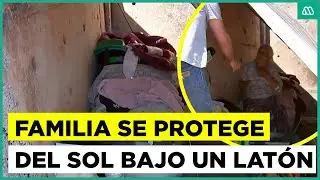 Familia se protege del sol bajo un techo de latón