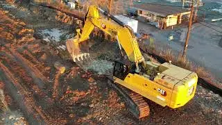 Cat 395ME loading Cat and Volvo dump trucks