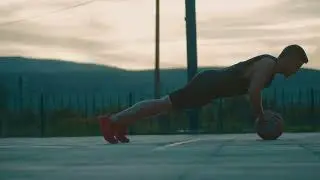 VideoVault Stock Video: Basketball player doing push-ups on the ball