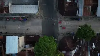 Aerial top down tripod view showing daily life and traffic with mototaxis and motorcycles driving