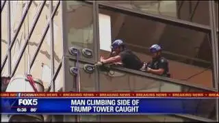 Police pull the man who was climbing Trump Tower into the building.