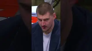 Nikola Jokic eats grapes on the bench and makes intense eye contact with the viewers at home