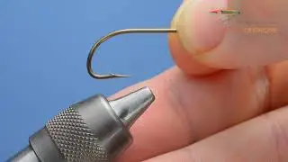Montage des mouches : Placer un hameçon dans les mors d'un étau.