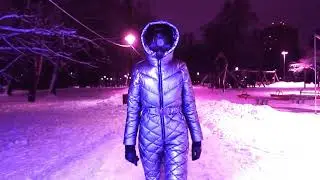 Night New Year walks in a silver ski suit - a snow suit, and a modern black panoramic gas mask