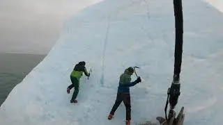 Idiots climb an iceberg which flips over