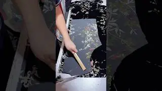 Для раскроя одежды используется черная шелковая ткань с узором из бабочек и цветов.
