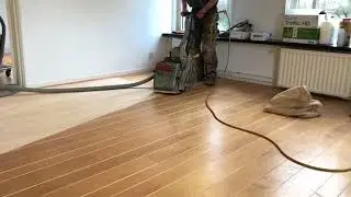 Schuren van een houten vloer met schuurmachine
