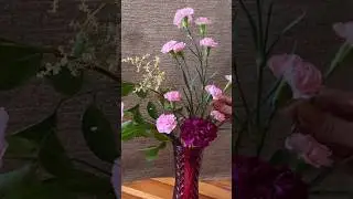 Flower arrangement with pink carnations in a red vase