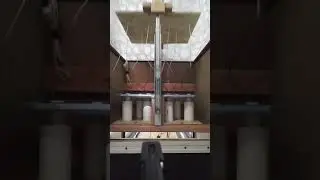 Mini bowling pin string setter in action from behind the lane