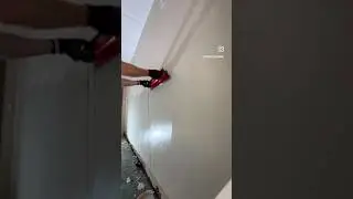 Plasterer working on achieving smooth surface over rough render wall. This method saved thousands.