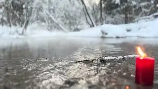 A candle burns in a winter forest 