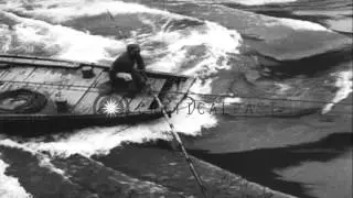 Chinese Laborers pull boats upstream from a river which runs between high mountai...HD Stock Footage