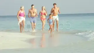Multi Generation Family Having Fun In Sea On Beach Holiday. Stock Footage