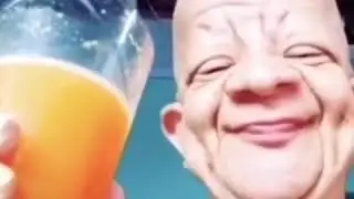 Bald guy drinks orange juice