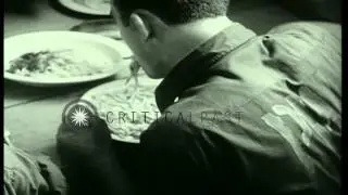 German and Italian prisoners cook meal and eat at a counter canteen in a POW camp...HD Stock Footage