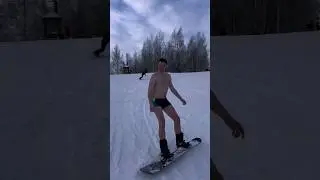 В одних плавках на сноуборде. Горы. Зима. Снег. Сноуборд