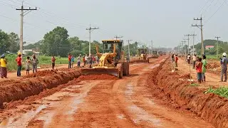 Machines Action: Motor grader push red dirt across a vast urban road