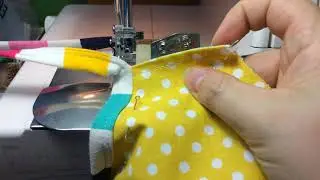 Binding a contoured face mask. Outer curves using the binding attachment on a coverstitch machine.