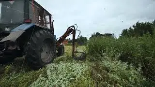 Tractor mowing green field, performing routine agricultural land maintenance task