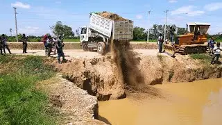 Dump Truck dumped soil dirt into a flooding | Building Road By Bulldozer Pushing of Village