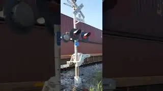 Long Cargo Ship Container Train.  And Train Warning Gate is Noisy going back up.