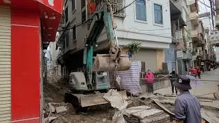 Excavator in Action Lifting Heavy Concrete Slabs for Manhole Covers!